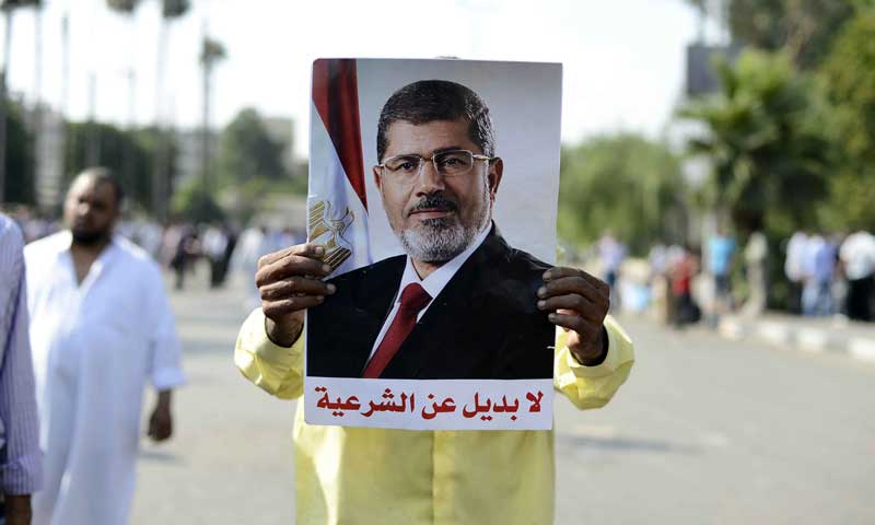 A supporter of Mohamed Morsi holds a picture of him during a rally outside Cairo University.  &mdash; Photo by AFP