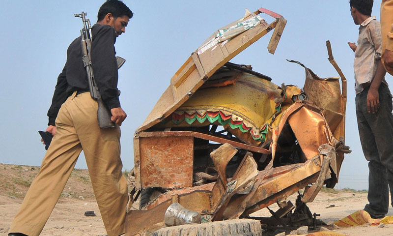 A policeman walks past the mangled wreckage of the motorcycle rickshaw after a train collided with the vehicle in Khanpur, district Sheikhupura on July 6, 2013.—AFP Photo