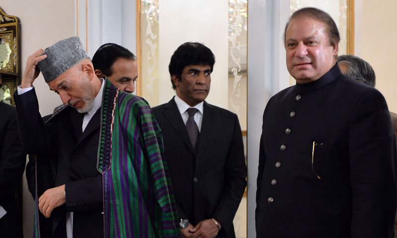 Visiting Afghan President Hamid Karzai (L) adjusts his cap as he arrives with Pakistani Prime Minister Nawaz Sharif (R) for a press conference at the Prime Minister's House in Islamabad on August 26, 2013. —AFP Photo