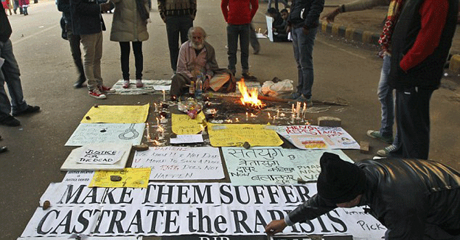 An Indian man arranges posters on a road during a protest to mourn the death of a gang rape victim in New Delhi - File Photo