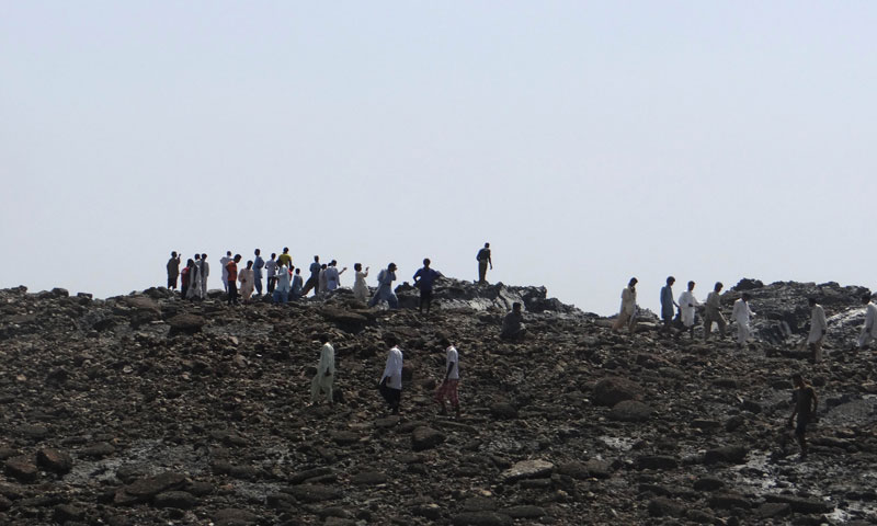 In this photo released by the Pakistani Government, men walk on an island that appeared 2 kilometres off the coastline of Gwadar on September 25, 2013, after an earthquake the day before. —AFP PHOTO/ Pakistan Government