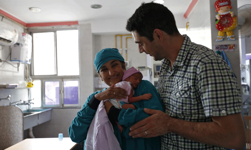 Briton Rekha Patel, 42, proudly holds her week-old-baby girl Gabriella, as her husband Daniele Fabbricatore, 39, watches inside an intensive care unit at the Akanksha IVF centre - Photo by Reuters