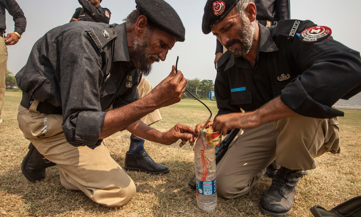 Technicians from Pakistan's top bomb disposal unit prepare an improvised detonator, by fixing a cord into a plastic water bottle, to demonstrate how to destroy militant bombs at the unit's headquarters in Peshawar. &ndash; Photo by Reuters