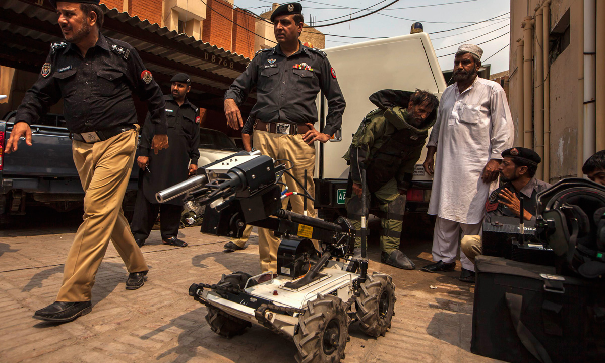 Shafqat Malik (Centre), head of a police bomb disposal unit, watches his team display their equipment during a demonstration at the unit's headquarters in Peshawar. &ndash; Photo by Reuters