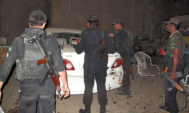 Security officials gather at the site of a suicide bomb blast in the outskirts of Dera Ismail Khan October 16, 2013. — Photo by AFP