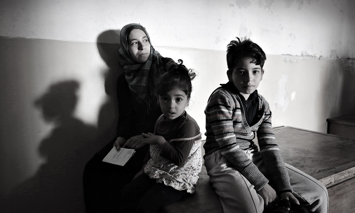 A Syrian mother and her children wait to receive medical help at a recently opened refugee camp sheltered in an old school in the outskirts of the capital Sofia, Saturday, Oct. 19, 2013.  The impoverished Balkan state has seen a considerable refugee influx over the past months, with authorities saying the number of asylum seekers in the country may reach up to 20,000 by the end of the year. - AP Photo