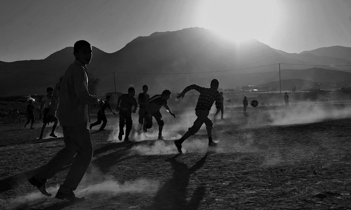 Afghan children play soccer in front of the ruined Darul Aman Palace on the outskirts of Kabul on October 19, 2013.  Nestling beneath the mountains that ring Kabul, the shattered shell of the Darul Aman palace stands in mute testimony to the brutality and callousness of Afghanistan's history of conflict. - AFP Photo