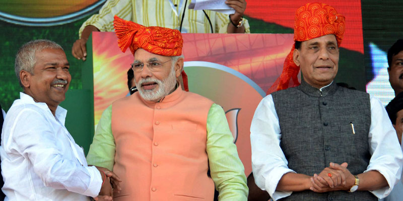 India's main opposition Bharatiya Janata Party's prime ministerial candidate Narendra Modi, shakes hands with a supporter as he stands next to party president Rajnath Singh, right, at a rally to in Patna, India, Oct.27, 2013. — Photo by AP