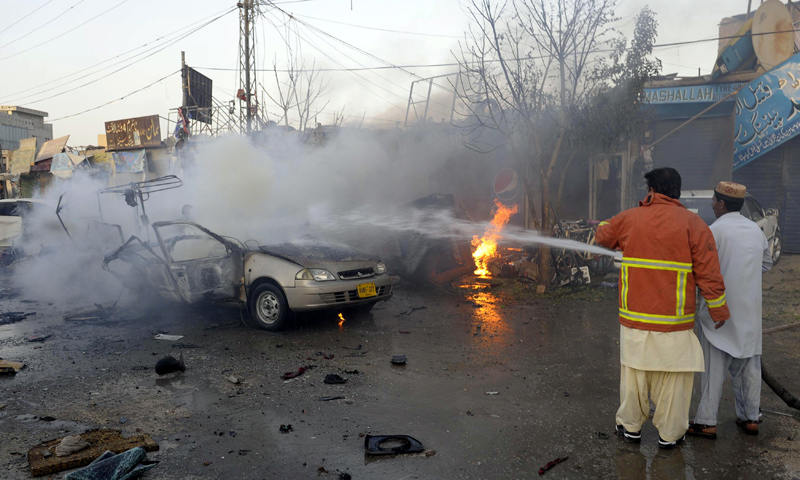 Firefighters extinguish burning vehicles after a bomb explosion in Quetta on Oct 30, 2013. — AFP Photo