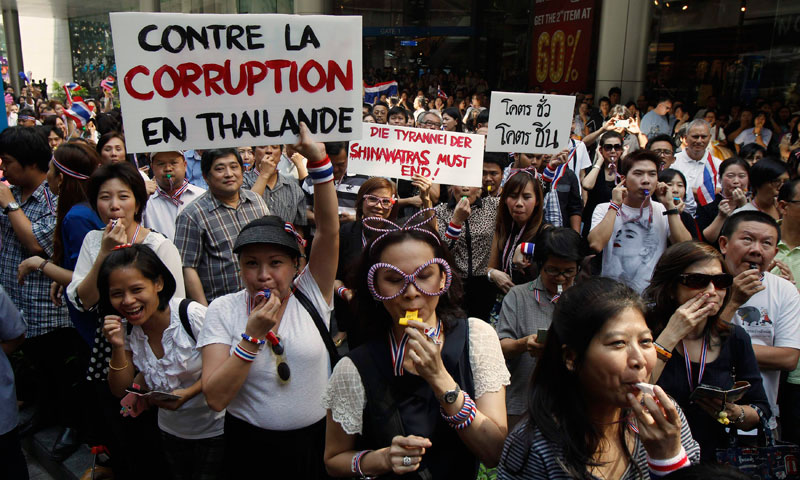 Protesters blow whistles and hold placards during a rally against the government-backed amnesty bill at Asoke intersection, in the heart of Bangkok's main shopping district. — File photo by Reuters