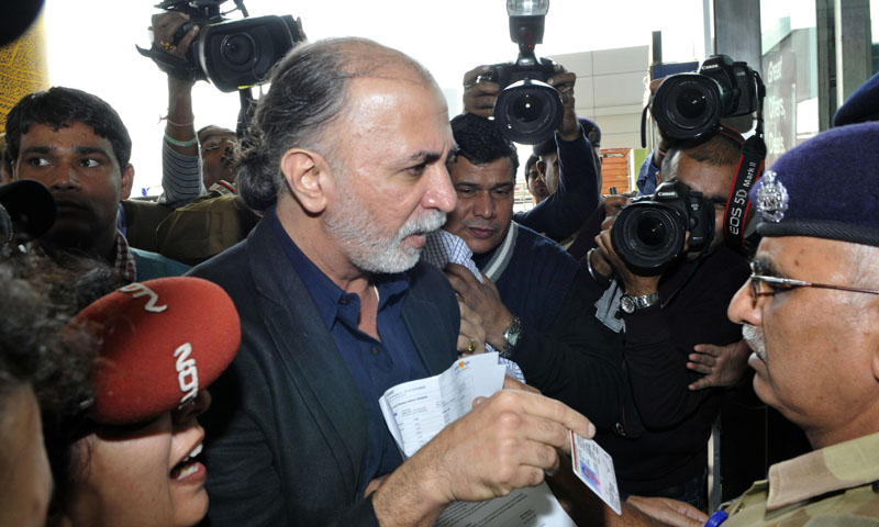 Indian magazine editor Tarun Tejpal (C) shows his identity card to an official as he enters the airport in New Delhi on November 29, 2013, ahead of travelling to the western city of Goa where he is due to be questioned by police. Tehelka's founder and editor Tarun Tejpal is under investigation over claims he sexually assaulted a woman twice in a hotel in the holiday state of Goa.   — Photo by AFP