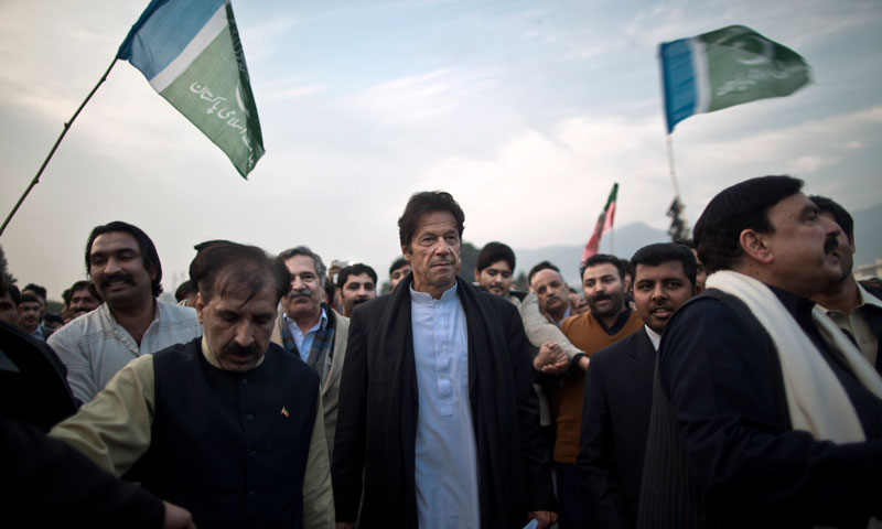 PTI chief Imran surrounded by supporters and party members march toward the parliament during a protest against US drone strikes, in Islamabad, Pakistan, Thursday, Dec. 5, 2013. – AP