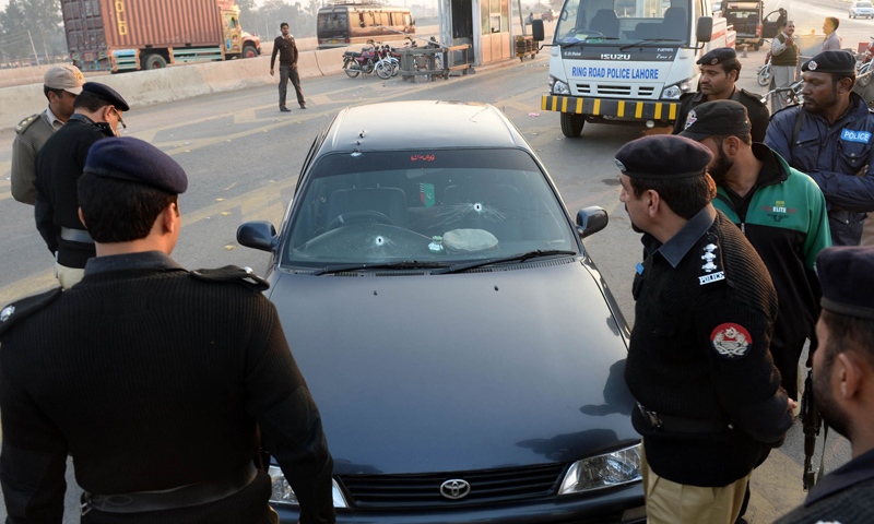 Police officials examine the bullet-riddled vehicle of ASWJ leader Maulana Shamsur Rehman Muavia after an attack by gunmen in Lahore on December 6, 2013.—AFP Photo