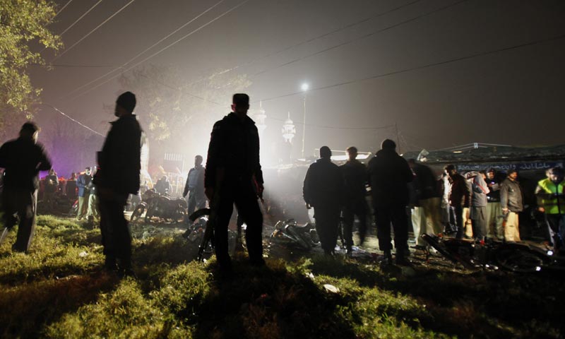 Police commandos secure an area while security officials examine the site of a suicide bombing in Rawalpindi. -AP Photo