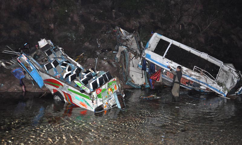 A volunteer looks at the wreckages of passenger buses that plunge into 50 meters ravine after colliding with each other in Salgran near Murree on Wednesday, Jan 8, 2014. – AP Photo