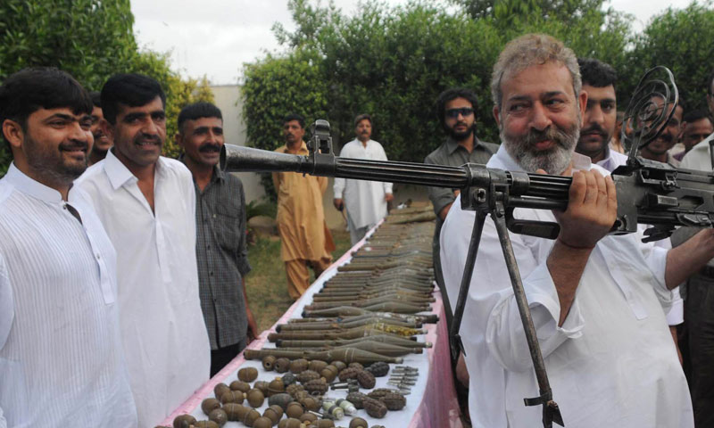 In this picture taken on May 11, 2012, Pakistan's senior police investigator Chaudary Aslam holds a machine gun recovered from militants with other ammunition in Karachi. — Photo by AP