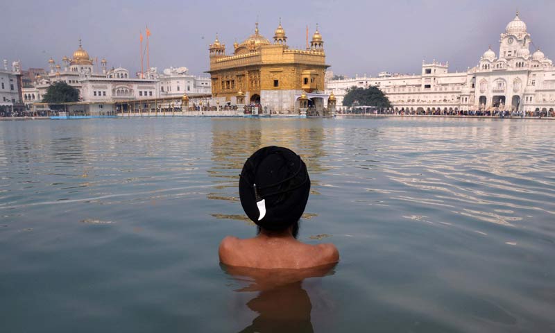 An Indian Sikh devotee takes a dip in the holy sarover (water tank) during the Maghi Mela at the Sikh Shrine Golden Temple in Amritsar. -AFP Photo