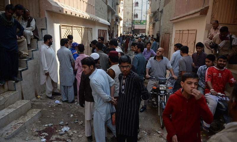 Residents gather at the site of a gunmen attack on health workers in Karachi on January 21, 2014. — Photo by AFP