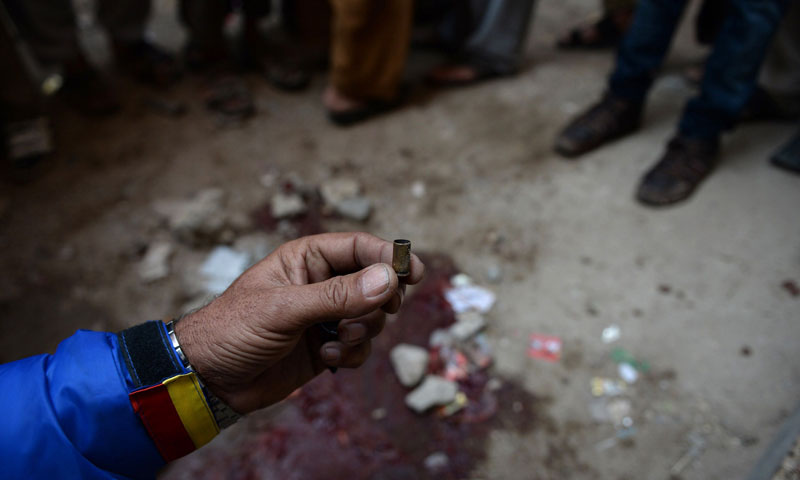 A volunteer holds up an empty bullet casing at the site of a gunmen attack on health workers in Karachi on Jan 21, 2014. — Photo by AFP