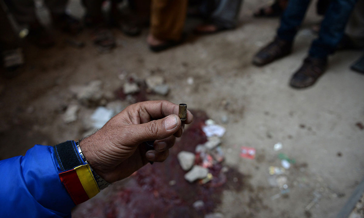 A Pakistani volunteer holds up an empty bullet casing at the site of a gunmen attack on health workers in Karachi on January 21, 2014. – Photo by AFP