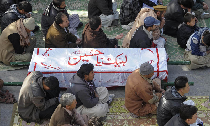 Relatives and mourners of  Shia pilgrims who were killed on Tuesday by a bomb blast, protest sitting next to their bodies, in Quetta, Wednesday, Jan. 22, 2014.—AFP Photo