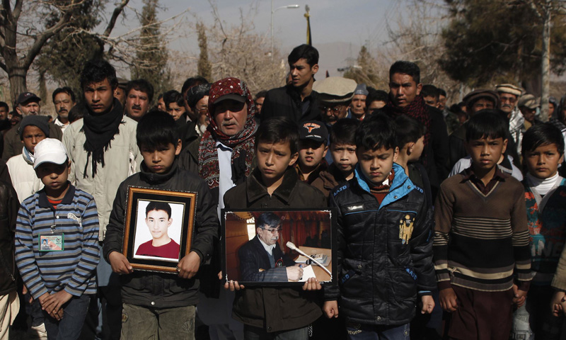 Shia Muslim men hold pictures of victims who were killed in Tuesday's night bomb attack on a bus, as they attend a funeral ceremony in Quetta January 24, 2014. – Reuters Photo