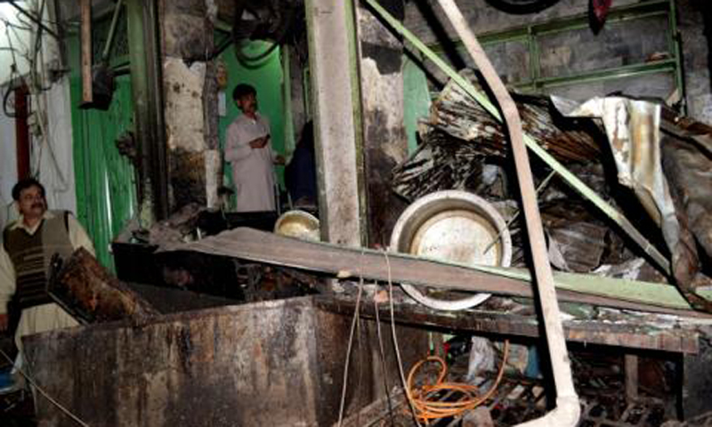 People inspect site of the suicide bombing in Peshawar on Tuesday night. – Photo by Zahir Shah Sherazi