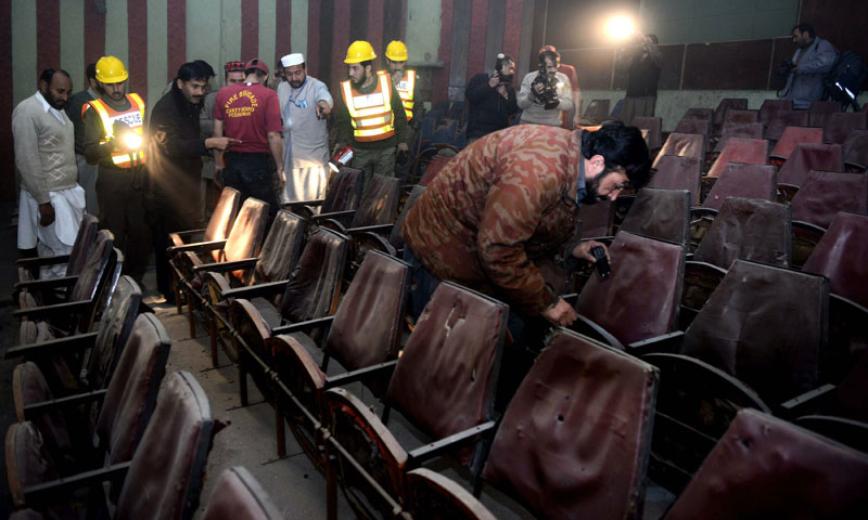 Volunteers search a cinema hall after a grenade attack in Peshawar on February 11, 2014. — File photo