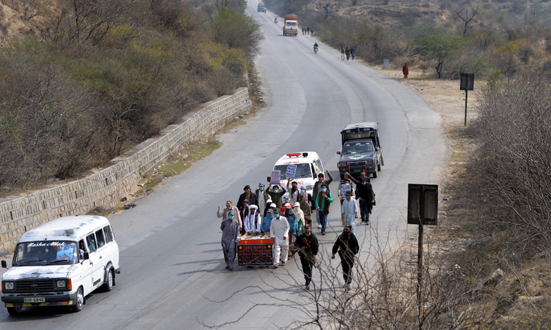 In this photograph taken on February 24, 2014 a group of Baloch people, led by Mama (uncle) Qadeer push a hand cart carrying the pictures of their missing loved ones as they walk along the Grand Trunk Road in the town of Dina, some 100 kilometers south of Islamabad.  — Photo by AFP