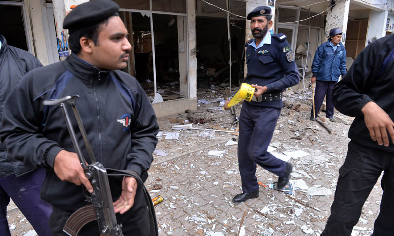 Policemen inspect a local court building after a gun and bomb attack in Islamabad, March 3. — AFP