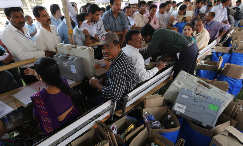 JORHAT: Polling officers queue up to collect election material at a distribution centre ahead of general election in this district of the northeastern Indian state of Assam on Sunday.—Reuters