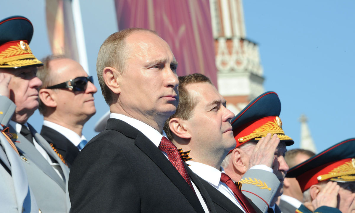 Russia's President Vladimir Putin (2nd Left) and Prime Minister Dmitry Medvedev (3rd Left) attend a Victory Day parade at the Red Square in Moscow, on May 9, 2014. – Photo by AFP