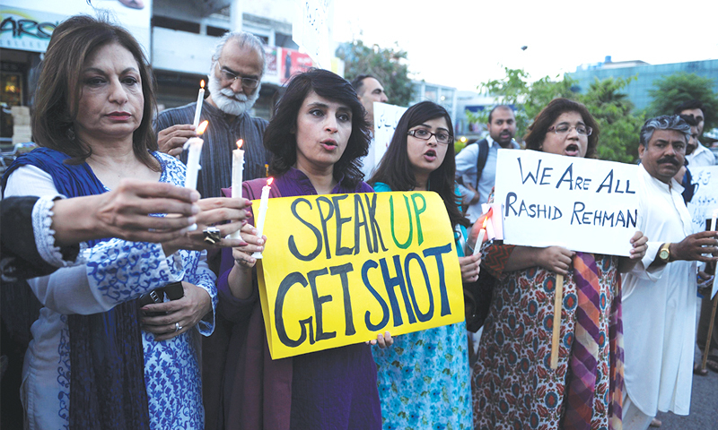 Activists in Islamabad hold candles and placards during a protest on May 8, 2014 against Rashid Rehman’s killing . The number of protestors contines to dwindle amidst an incredible level of threats and intimidation. —AFP file photo