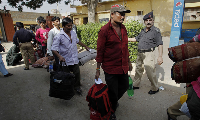 Indian fishermen walk toward a bus to leave for their homeland following their release from a prison in Karachi, Pakistan, Sunday, May 25, 2014. — Photo by AP