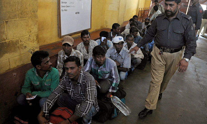 A Pakistani policeman performs a head count before releasing jailed Indian fishermen from a Pakistani prison in Karachi on May 25, 2014.— Photo by AFP