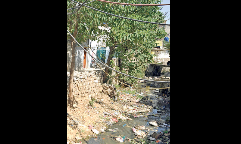 6. Some irregular settlements along the natural streams, like this one in Sector F-7, have made it impossible for the CDA to repair or replace broken sewage trunk lines. All sewage trunk lines were laid along the natural streams when the new capital was built in the 1960s.