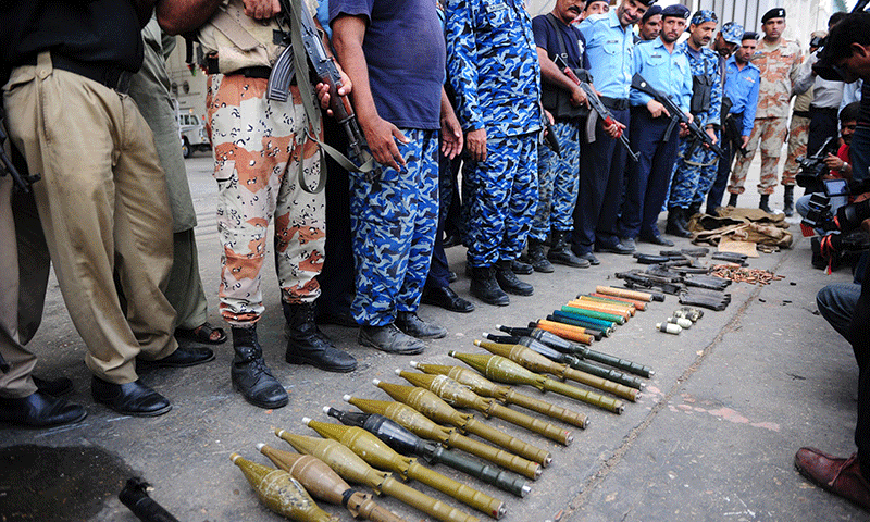 Policemen show seized weapons after militants attacked Jinnah International Airport in Karachi on June 9, 2014. — Photo by AFP