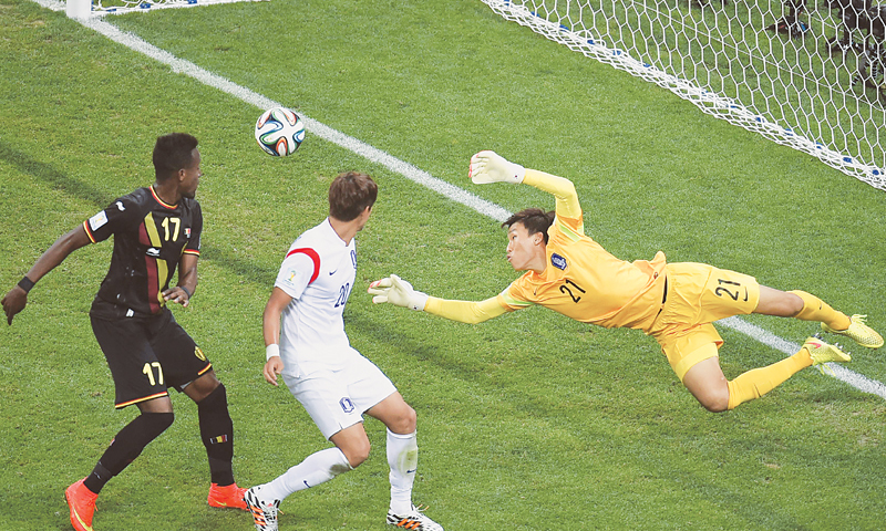 South Korean goalkeeper Kim Seung-Gyu tries to make a save during the match against Belgium.—AFP
