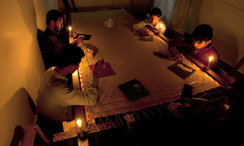 File photo shows Pakistani embroiderers working by candle light.&mdash;AP/File photo