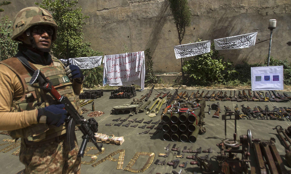 A Pakistani soldier stands by ammunition seized during a military operation against Taliban militants, in the of town of Miranshah, North Waziristan July 9, 2014. The Pakistani military has seized control of 80 percent of Miranshah, the capital of the remote North Waziristan tribal region where the military launched an operation against Islamist militants last month, a general said Wednesday. Picture taken July 9, 2014. REUTERS/Maqsood Mehdi (PAKISTAN - Tags: POLITICS CIVIL UNREST MILITARY)