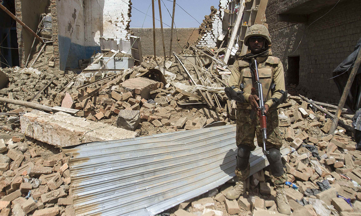 A Pakistani soldier stands beside a house which was destroyed during a military operation against Taliban militants, in the town of Miranshah, North Waziristan July 9, 2014. The Pakistani military has seized control of 80 percent of Miranshah, the capital of the remote North Waziristan tribal region where the military launched an operation against Islamist militants last month, a general said Wednesday. Picture taken July 9, 2014.   REUTERS/Maqsood Mehdi (PAKISTAN - Tags: POLITICS MILITARY CIVIL UNREST)