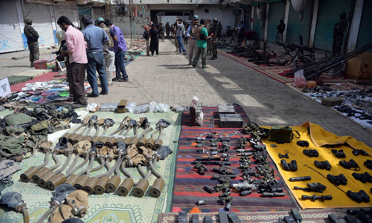 Pakistani media personnel take footage of seized weapons at an empty bazaar during a military operation against Taliban militants in the main town of Miranshah in North Waziristan on July 9, 2014. Last month Pakistan's military launched a long-awaited offensive in North Waziristan, aimed at wiping out longstanding militant strongholds in the area, which borders Afghanistan. More than 800,000 people have fled a major military offensive against the Taliban in a Pakistani tribal area, officials said Wednesday. AFP PHO