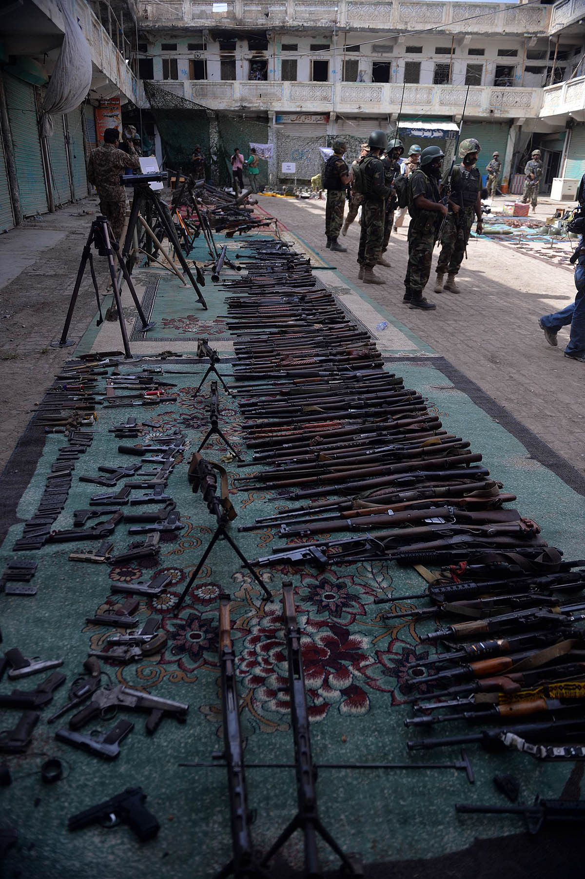 Soldiers stand by seized weapons at an empty bazaar during a military operation against Taliban militants in the main town of Miramshah in North Waziristan on July 9, 2014. — Photo by AFP