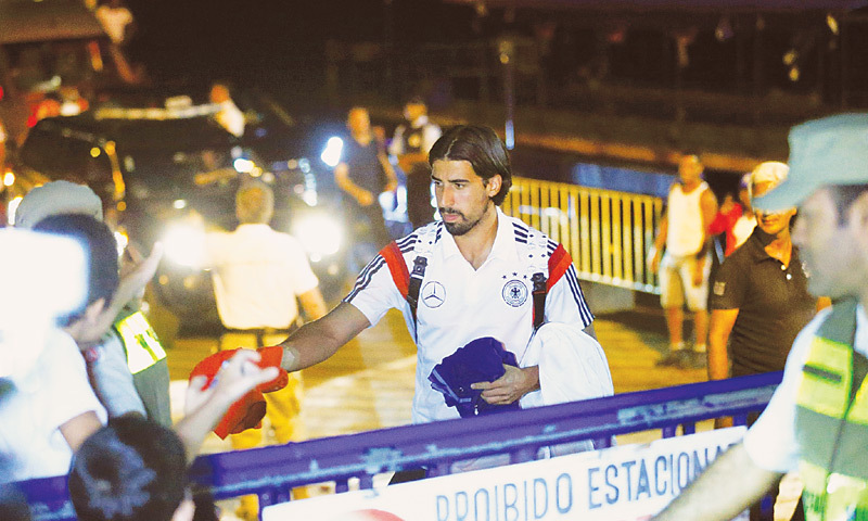 German player Sami Khedira gives away shirts to spectators as he leaves a ferry in the town of Santa Cruz Cabralia, north of Porto Seguro, on Saturday.—Reuters