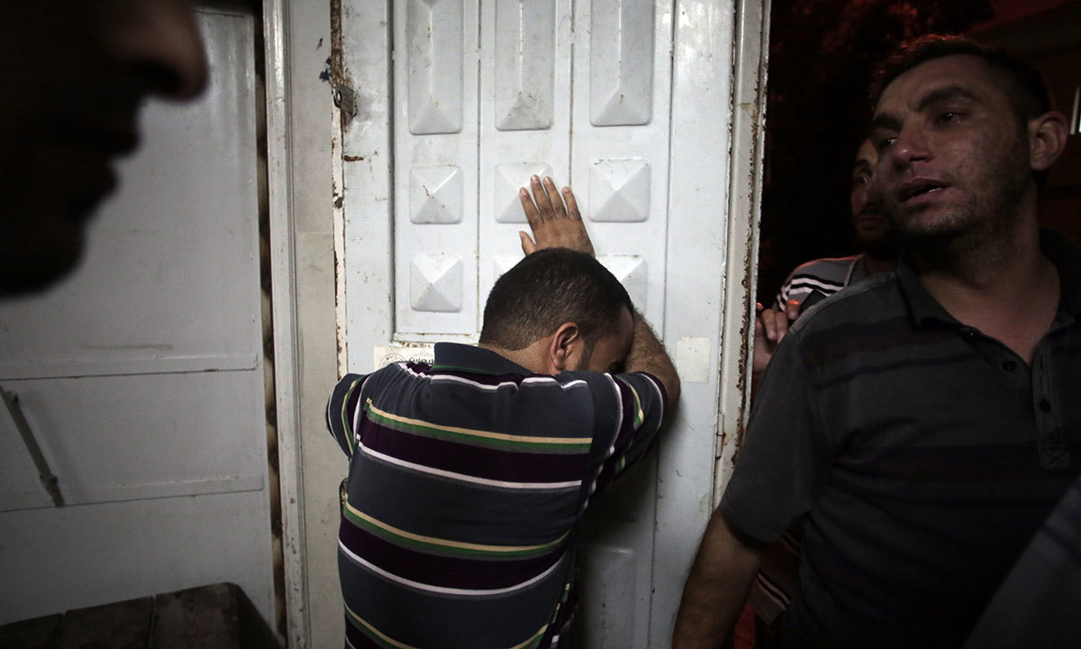 Palestinians mourn their relatives in the morgue of the Shifa hospital in Gaza City on Saturday, July 12, 2014. — Photo by AP