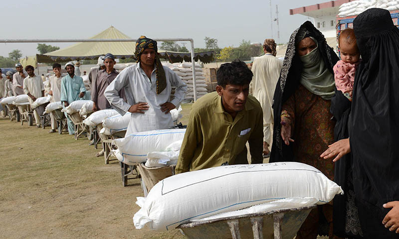 Workers prepare to distribute food supplies to civilians, fleeing a military operation in the North Waziristan tribal agency, at a World Food Programme aid distribution centre in Bannu. — File photo by AFP