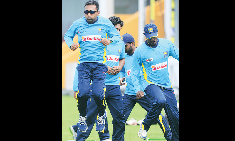 Mahela Jayawardene (L) and team-mates undergo warm up exercises.—AFP