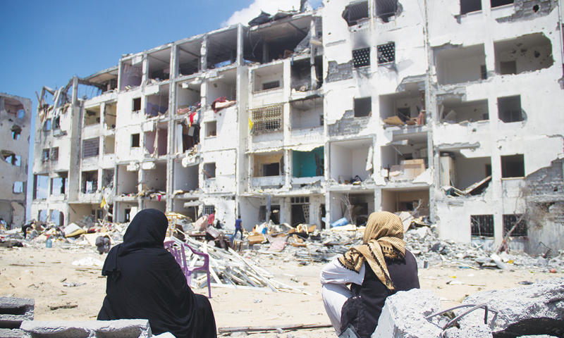 Palestinian women sit among the ruins of the Al-Nada towers after they were destroyed by Isralei strikes in Beit Hanoun, northern Gaza Strip. &mdash;Photo by Basel Yazouri/ ActiveStills