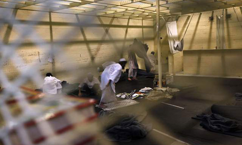 Afghan detainees, seen through a mesh wire fence, prepare for noon prayers inside the Parwan detention facility near Bagram Air Field in Afghanistan. – AP File Photo