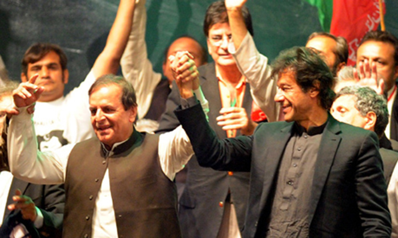 Imran Khan (R) joins hands with his party leader Javed Hashmi (L) during a public meeting. — Photo by AFP